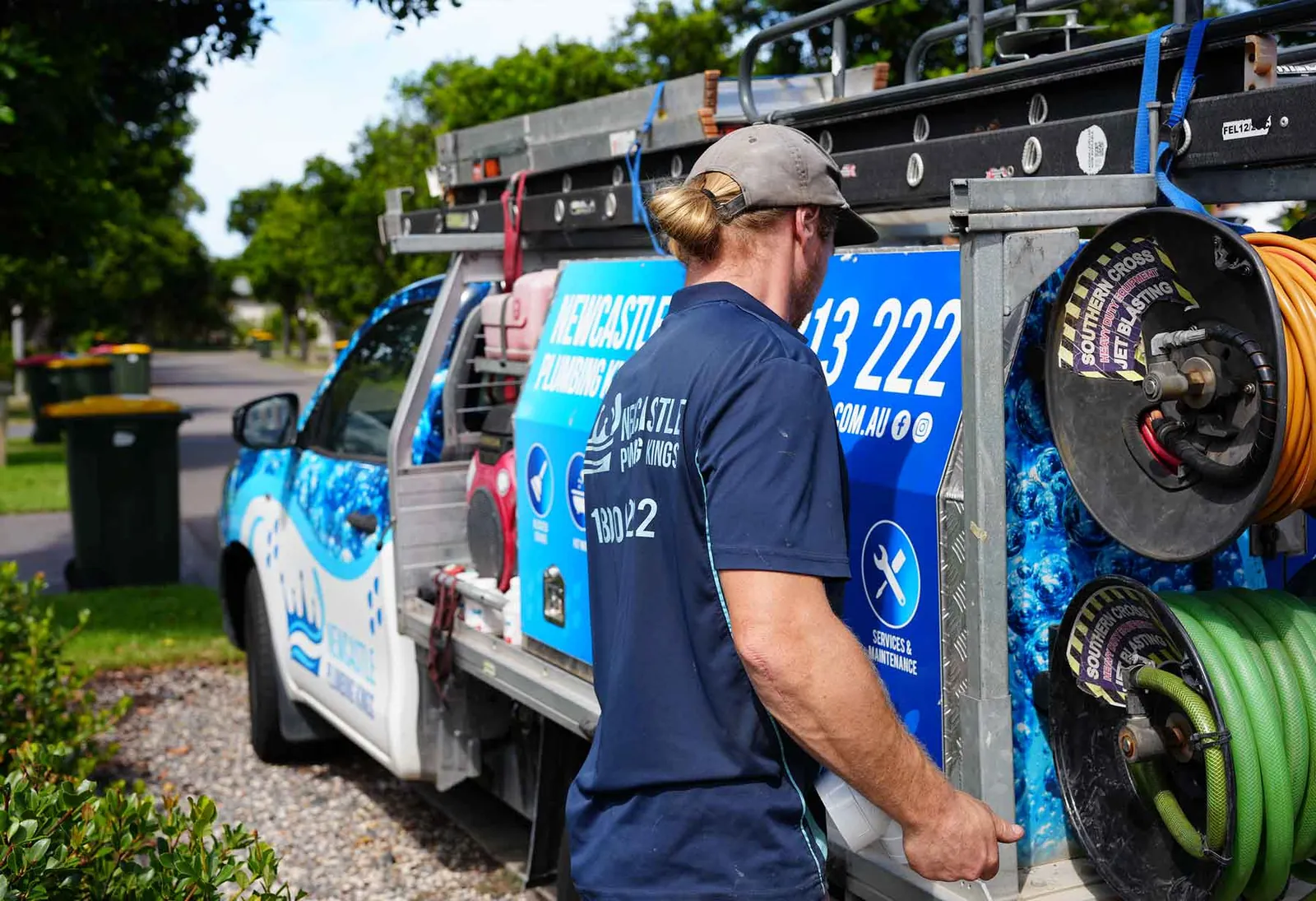 Plumber working at the hose reels on the back of the ute